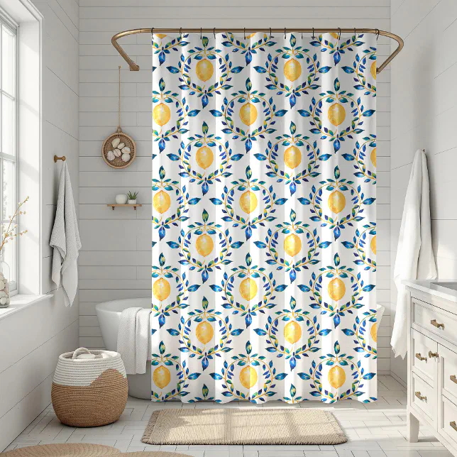 Italian lemon printed shower curtain shown in use in a bathroom. In the background there is a beige rug,  white towels, and a white sink. 