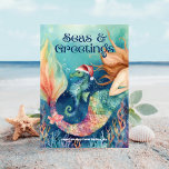 Mermaid & Seahorse Santa Beach Christmas Holiday Card<br><div class="desc">Send a splash of holiday cheer with this “Seas & Greetings” flat Christmas card! Featuring a festive mermaid 🧜‍♀️ and her cute seahorse friend donning a Santa hat 🎅, this whimsical design brings a beachy twist to the season. Set against an under the sea background, this cheerful card captures the...</div>