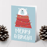 Merry & Bright Polar Bear Christmas Holiday Card<br><div class="desc">Wish friends and family a beary Merry Christmas with our Merry & Bright holiday greeting card. The front of the holiday greeting card features a polar bear wearing a red turtleneck wrapped in colorful Christmas lights against a blue background. The phrase "Merry & Bright" are displayed below in a white,...</div>