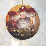 Merry Christmas Family Photo Elegant Gold Script Ceramic Ornament<br><div class="desc">Spread holiday cheer to friends and family with this modern keepsake ornament. The gold faux foil text reads "Merry Christmas" in elegant handwriting script. Replace the sample image with your favorite photo,  and add your family name and the year. A black gradient filter helps make the text pop.</div>
