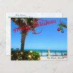 Merry Christmas from Vero Beach Florida Oceanfront Holiday Postcard<br><div class="desc">Merry Christmas from Vero Beach, Florida! This colorful tropical-themed postcard features a photo image of a beautiful Vero Beach oceanfront area all decked out for the holidays. The festive design includes Christmas lights on the greenery, Christmas balls hanging from a palm frond, and the text "Merry Christmas" in red script...</div>