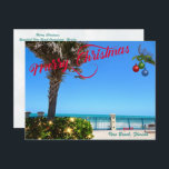 Merry Christmas from Vero Beach Florida Oceanfront Holiday Postcard<br><div class="desc">Merry Christmas from Vero Beach, Florida! This colorful tropical-themed postcard features a photo image of a beautiful Vero Beach oceanfront area all decked out for the holidays. The festive design includes Christmas lights on the greenery, Christmas balls hanging from a palm frond, and the text "Merry Christmas" in red script...</div>