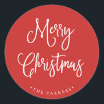 Merry Christmas | Handwritten Script on Red Classic Round Sticker<br><div class="desc">This simple and trendy holiday sticker says "Merry Christmas" in rustic,  white handwritten script on a bright,  holiday red background.</div>