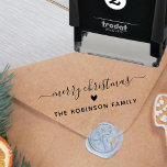 Merry Christmas Script Cute Heart Family Name  Self-inking Stamp<br><div class="desc">Modern Cute Merry Christmas Script Holiday Family Name self-inking Stamp. Features a „Merry Christmas” script in a hand lettered calligraphy swash tail font type,  a love heart symbol and family name.</div>