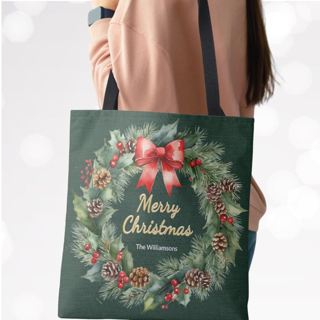 Merry Christmas Wreath with Red Bow Personalized Tote Bag (A festive green tote bag with faux gold "Merry Christmas" greeting, wreath surround and custom name)