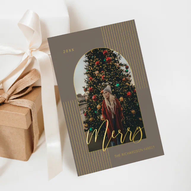 Gold real foil holiday card with a line and arch design next to beige and white wrapped gifts.