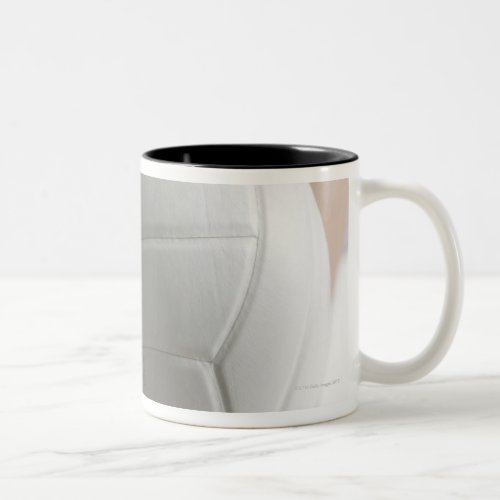 Mid section view of a young woman serving a Two_Tone coffee mug