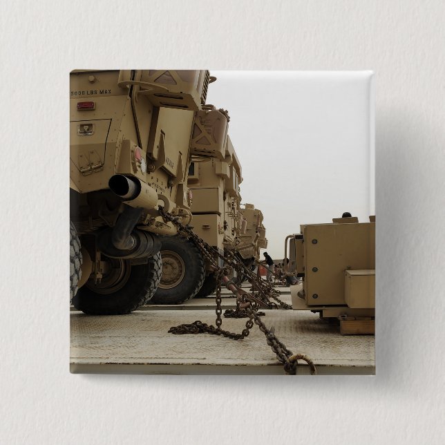 Military vehicles are locked down on semi truck button (Front)