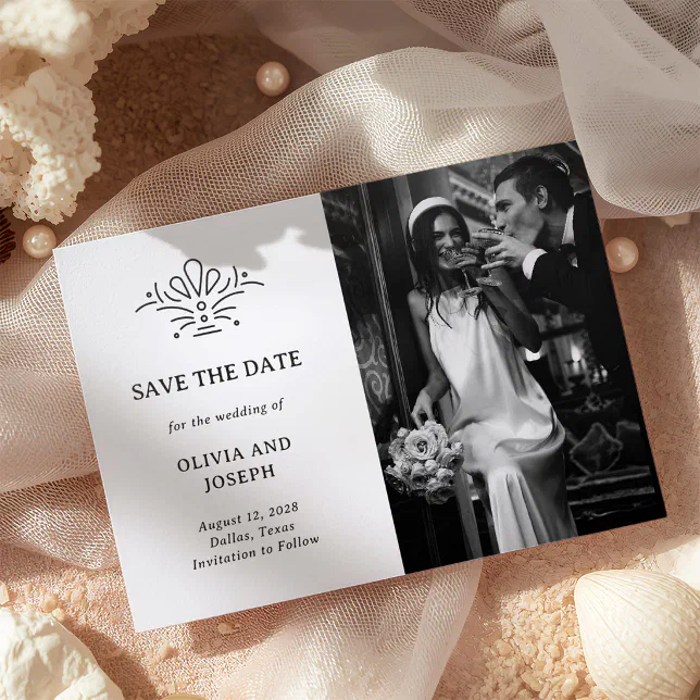 A minimal art deco letterpress-photo Save the Date sits atop cream and beige textured material.
