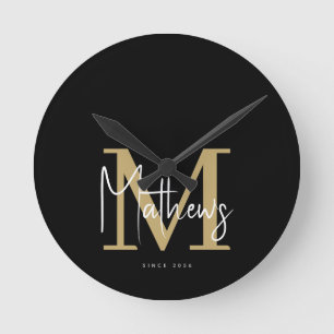 Modern Black Gold White Monogram Family Name Round Clock