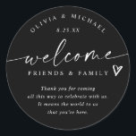Modern Black & White Wedding Welcome Hotel Bag Classic Round Sticker<br><div class="desc">Black and White Hotel Bag Stickers: Make a sleek first impression with these black and white modern handwriting wedding welcome stickers. Each 3-inch round label features the phrase “welcome friends & family” in crisp white script with a small heart accent and room for your short message. The couple’s names and...</div>