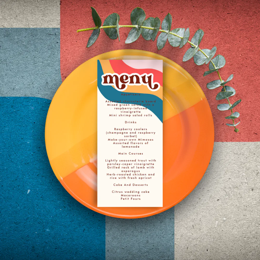 A groovy 70s-inspired wedding menu with retro rainbow waves, presented on an orange plate with a eucalyptus sprig and a red and blue color-blocked backdrop.
