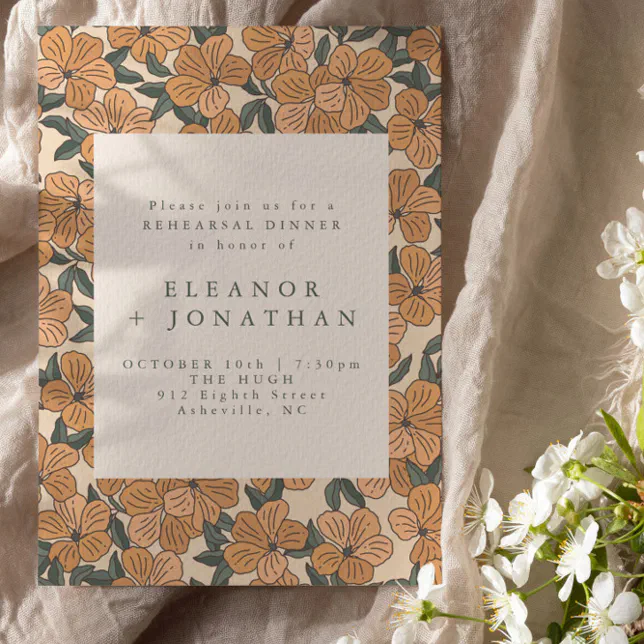 A rehearsal dinner invitation with a vintage floral theme. The pattern consists of flowers in green and orange.