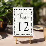 Modern Cream and Black Wavy Frame Wedding Table Number<br><div class="desc">Add a stylish touch to your wedding celebration with these Modern Wavy Frame wedding table cards! The retro design displays "Table" in a handwritten black script with the table number shown below. A black wavy border surrounds the table number contrasting with a light cream background. The design repeats on the...</div>