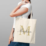 Modern Elegant Gold Black Personalized Monogram Tote Bag<br><div class="desc">Modern and elegant tote bag features a simple and minimal custom gold and black (colors can be modified) personalized monogram design that can be personalized with an initial and name in script. Perfect gift for your wedding party - maid of honor, bridesmaids, mothers of the bride and groom, and flower...</div>