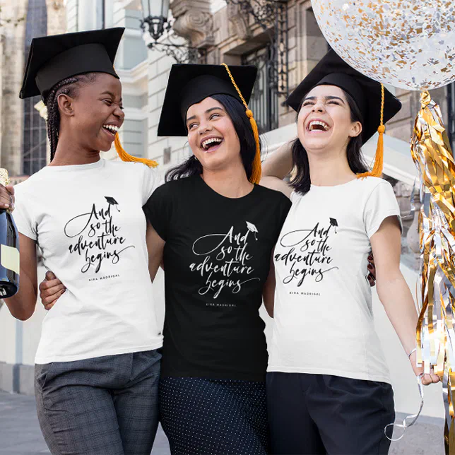 Three people smiling and hugging wearing graduation T-Shirts and graduation caps.
