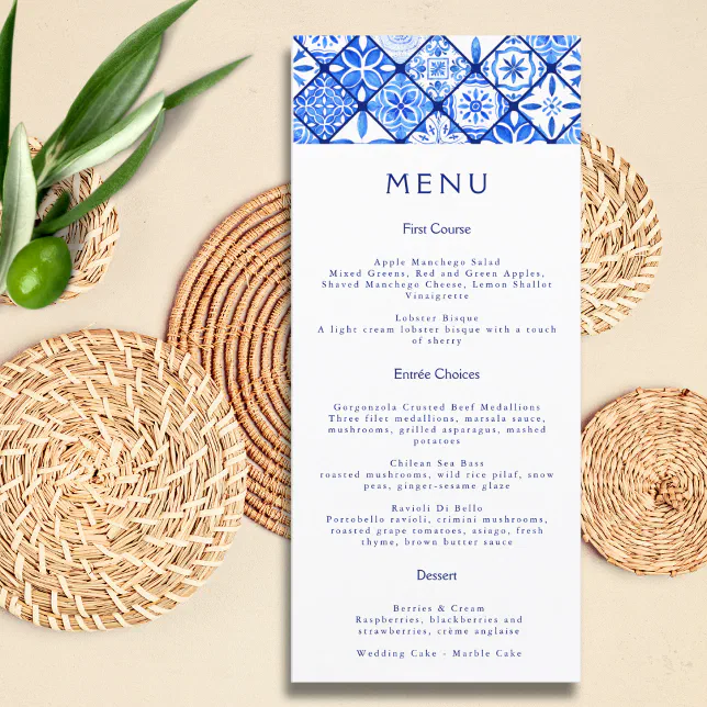 A Mediterranean-themed menu with a blue and white color scheme. Plates made of a wicker-like material are lying underneath the menu.