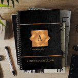 Modern monogram black gold name script elegant planner<br><div class="desc">A classy elegant business or personal 2026 black planner featuring gold copper metallic geometric monogrammed square label on a black leather look background. Perfect for a stylish business image for a business corporate manager, director, fashion stylist, home interior decorator, designer, architect, beauty salon manager, makeup artist, hairstylist. Easy to personalize...</div>