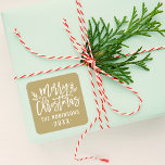 Modern Script Gold Merry Christmas Custom Square Sticker<br><div class="desc">Stylish Merry Christmas holiday favor sticker features white script writing and accents of branches with holly leaves and berries. Personalize with custom name / family and year text. The antique gold background color can be modified.</div>