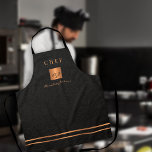 Monogram elegant black gold name script chef apron<br><div class="desc">Monogrammed stylish luxury exclusive kitchen restaurant master chef apron featuring a faux gold copper metallic glitter square and lines over a stylish classy faux black leather (PRINTED TEXTURE) background.           Personalize it with title,  name and initials.</div>