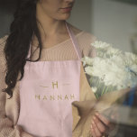 Monogram Elegant Minimal Blush Pink and Gold Apron<br><div class="desc">A simple stylish custom monogram design in a gold modern minimalist typography on an elegant pastel blush pink background. The monogram initials and name can easily be personalized along with the feature line to make a design as unique as you are! The perfect bespoke gift or accessory for any occasion....</div>