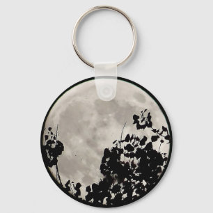 Moon behind dark leaves keychain