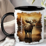 Moose in Misty Lake Reflection Mug<br><div class="desc">Savor your favorite beverage with the Moose in Misty Lake Reflection Mug. This captivating mug features a majestic moose standing in a misty lake, with the soft, golden hues of dawn and the tranquil forest beautifully reflected in the water. Customized with your name, it adds a personal and unique touch....</div>