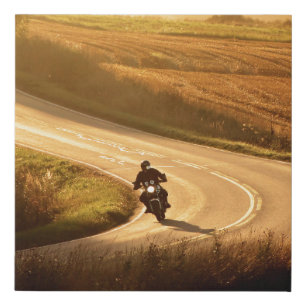 Motorcycle on countryside road at autumn evening. faux canvas print