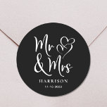 Mr Mrs Black Wedding Classic Round Sticker<br><div class="desc">A chic black sticker for your wedding correspondence and party favors featuring "Mr & Mrs" in a large white script and a white illustration of two hearts joined together. Add your name and wedding date.</div>