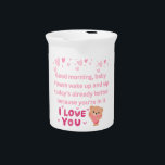 Mug Beverage Pitcher<br><div class="desc">This artwork is a gentle morning greeting designed to bring a smile to a loved one’s face. With soft pink tones, floating hearts, and a cuddly teddy holding a heart, it captures warmth and tenderness. The message, “Good morning, baby. Please wake up and sip today’s already better because you’re in...</div>