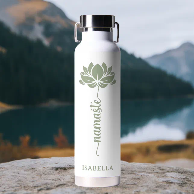A white waterbottle with a green motif and a steel cap is shown in front of a mountain and river background.