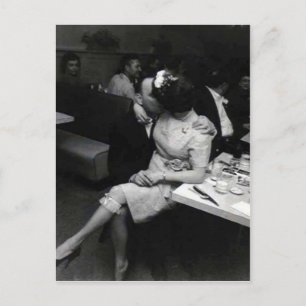 newlyweds kissing at a resturaunt postcard