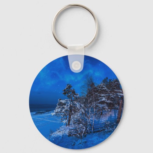 Nighttime winter scene with snow covered pines keychain