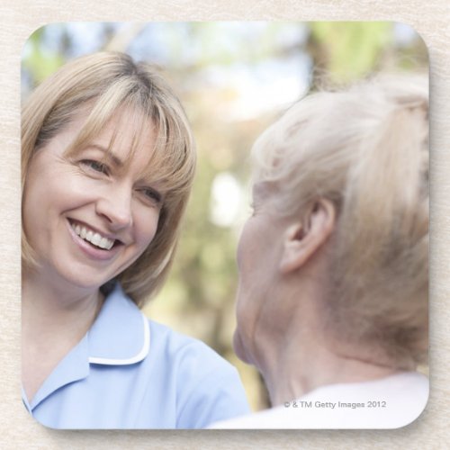 Nurse smiling and talking to a senior woman drink coaster
