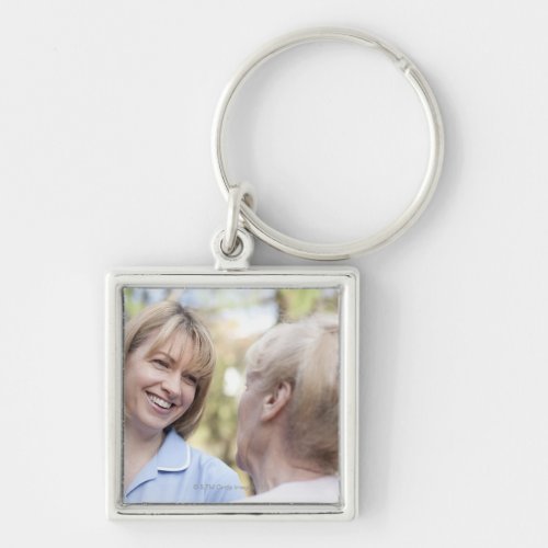 Nurse smiling and talking to a senior woman keychain