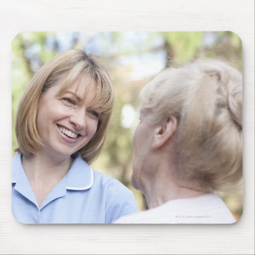 Nurse smiling and talking to a senior woman mouse pad