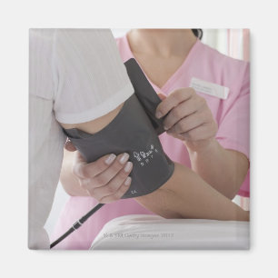 Nurse taking patient's blood pressure magnet