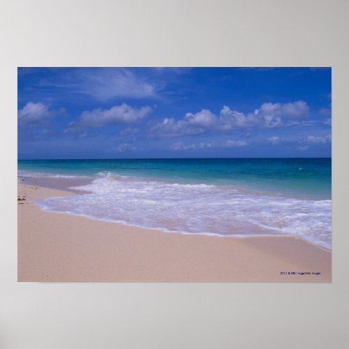 Ocean waves foaming onto sandy beach poster