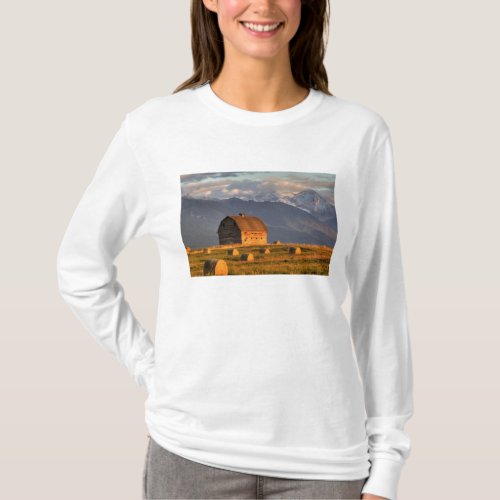 Old barn framed by hay bales and dramatic T_Shirt