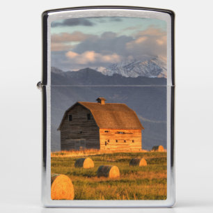 Old barn framed by hay bales and dramatic zippo lighter
