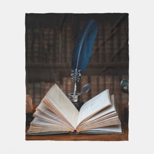 Old books quill pen and vintage inkwell on wooden fleece blanket