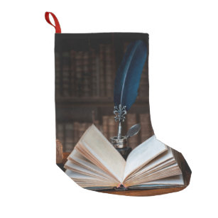 Old books, quill pen and vintage inkwell on wooden small christmas stocking