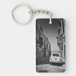 Old car in a street in Italy with sea Keychain