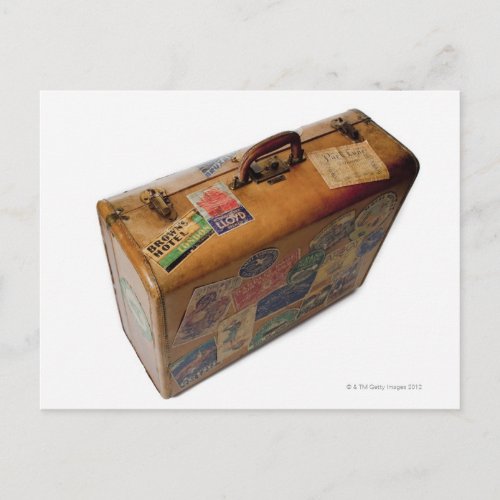 old fashioned suitcase with travel stickers postcard