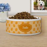 Orange Dog Paws Pattern With Custom Name Bowl<br><div class="desc">Orange dog paw print pattern background with a darker orange badge that has a personalizable text area for the name of the pet. The font is a lovely script font in white color.</div>