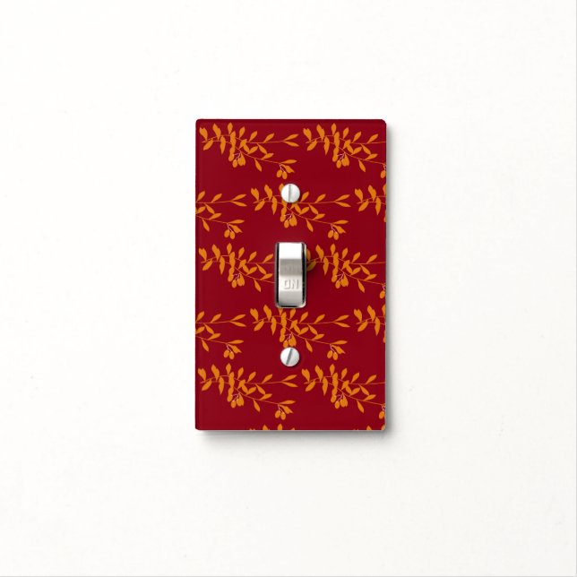 Orange silhouette branch leaves on red light switch cover (In Situ)