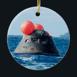 Orion Spacecraft Parachute Landing Ceramic Ornament<br><div class="desc">The Orion crew module spacecraft is designed to carry four astronauts on deep space missions and return them safely to Earth. Like the Mercury, Gemini and Apollo capsules before it, Orion will land softly using parachutes and be recovered in water landings. Unlike these earlier command modules, Orion is designed to...</div>