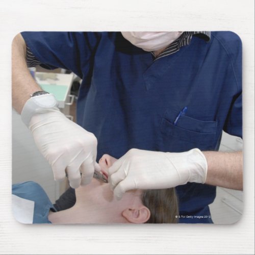 Orthodontist readjusting the dental braces of a mouse pad