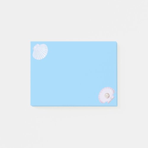 Oyster shell with pearl on light blue post_it notes