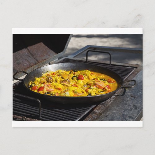 Paella is cooked on a grill postcard